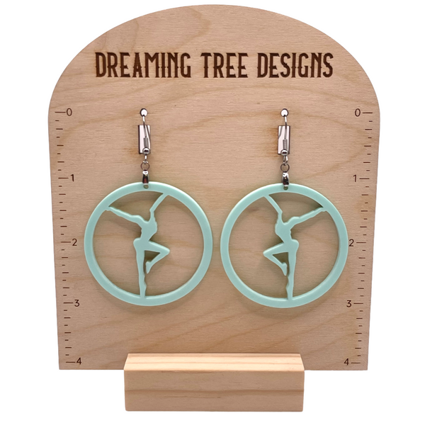 a pair of earrings on a wooden stand