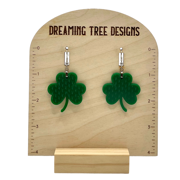 a pair of green earrings with a four leaf clover